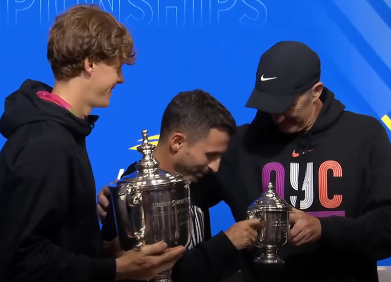 Jannik Sinner presents the trophy to his coaches Simone Vagnozzi and Darren Cahill