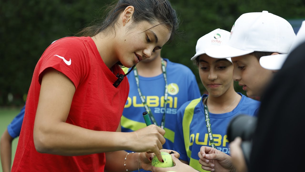 Emma Raducanu talks with the ballkids in Dubai